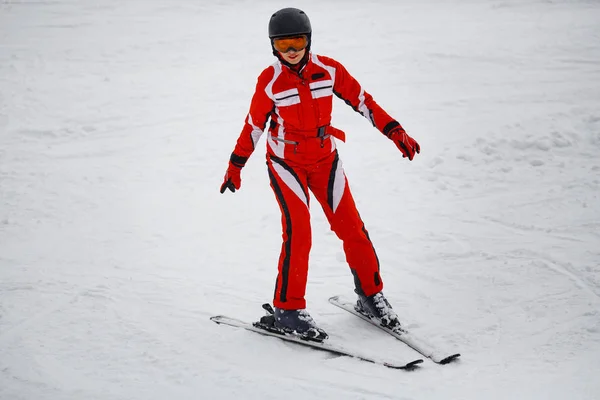 Girl in a red suit skis — Stock Photo, Image