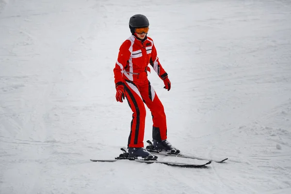 Dívka v červeném vhodné lyže — Stock fotografie