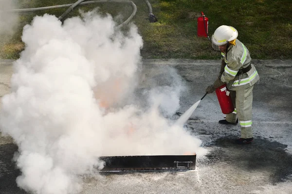 Pompier utilisant un extincteur — Photo