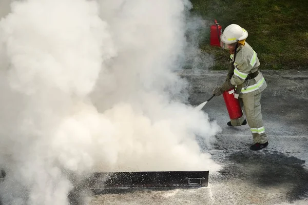 firefighter using fire extinguisher