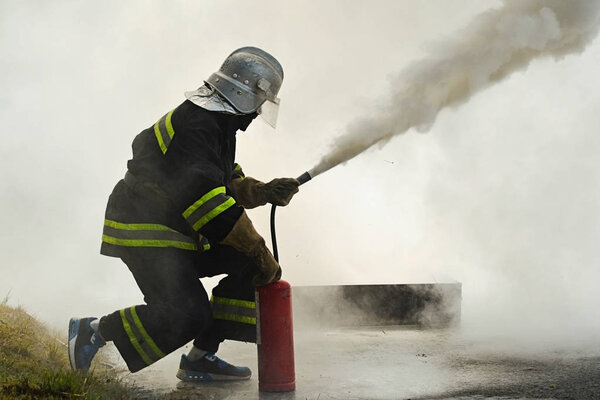 firefighter using fire extinguisher