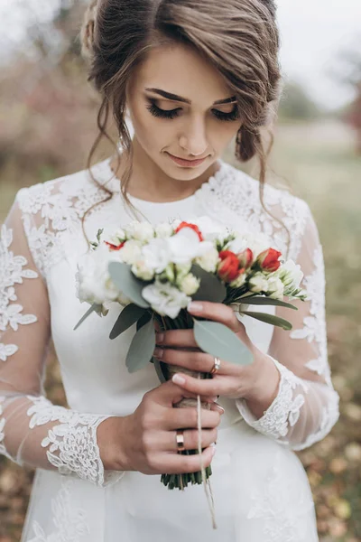 Braut in der Natur mit Blumenstrauß — Stockfoto