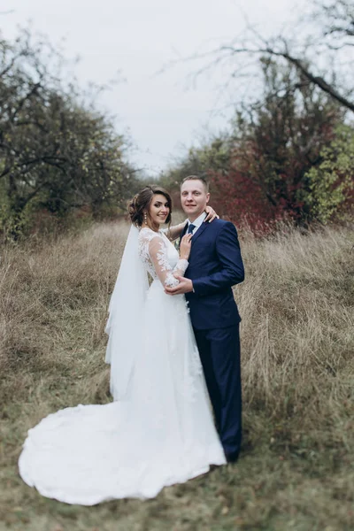 Mariée et marié marchant dans le parc — Photo