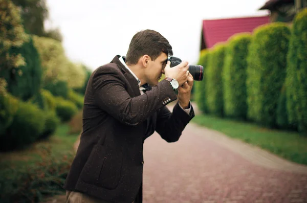 Young man with camera outdoors — Stock Photo, Image