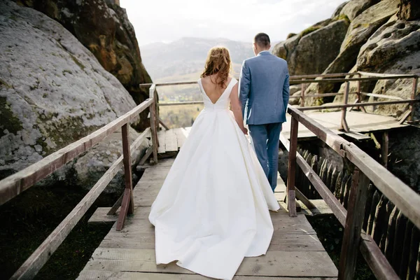 Pareja de boda caminando en las montañas — Foto de Stock