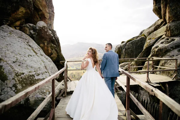 Pareja de boda caminando en las montañas — Foto de Stock