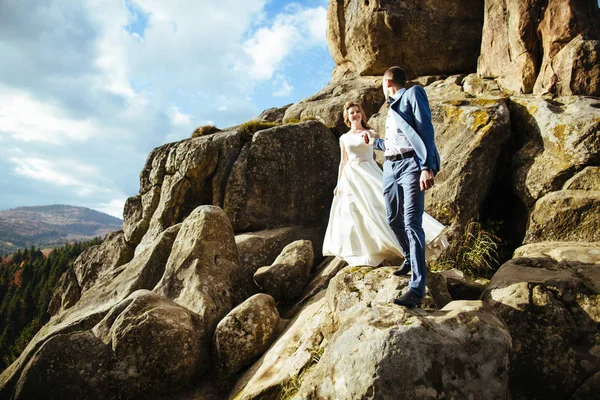 Pareja de boda caminando en las montañas — Foto de Stock