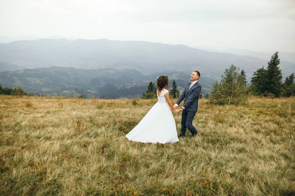 Pareja de boda caminando en las montañas — Foto de Stock