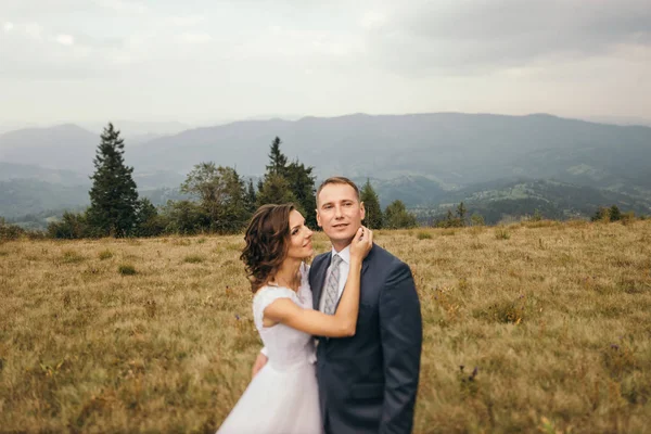 Casal de casamento andando nas montanhas — Fotografia de Stock