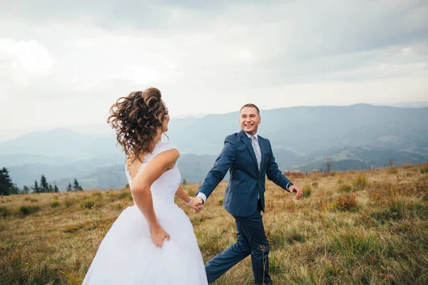 Couple de mariage marchant dans les montagnes — Photo