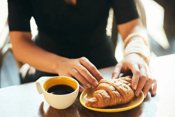 Hände mit Croissant und Tasse Kaffee — Stockfoto