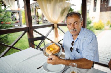 Adam holding khachapuri