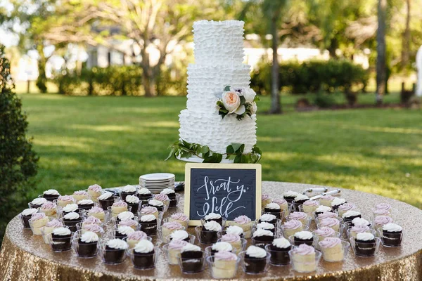 Прекрасный свадебный торт и кексы — стоковое фото