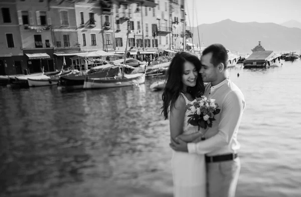 Bruden och brudgummen omfamnar i hamnen — Stockfoto