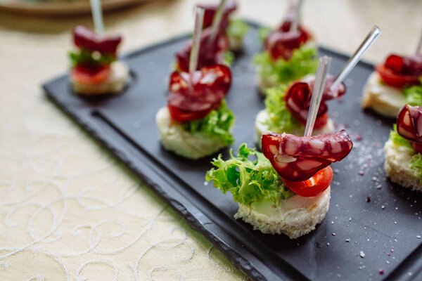 Испанские тапас на черной каменной тарелке
.