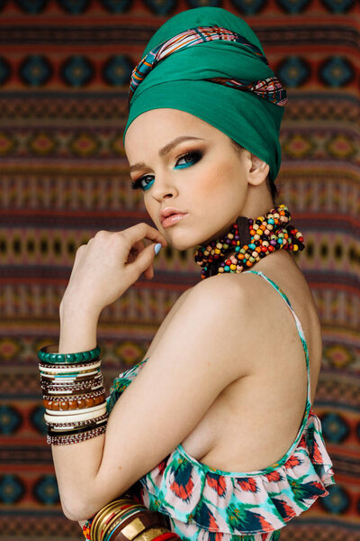 Portrait of beautiful young woman with bright make-up and turban