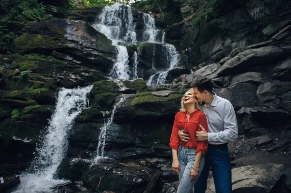 Par nära ett vattenfall i skogen. — Stockfoto