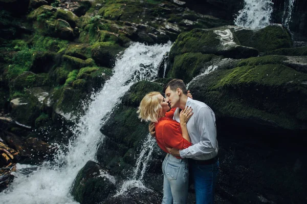 Pár poblíž vodopádu v lese. — Stock fotografie