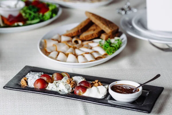 Scheibenkäse auf Teller mit Nüssen — Stockfoto