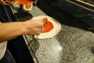 Aşçı mutfakta pizza yapıyor.