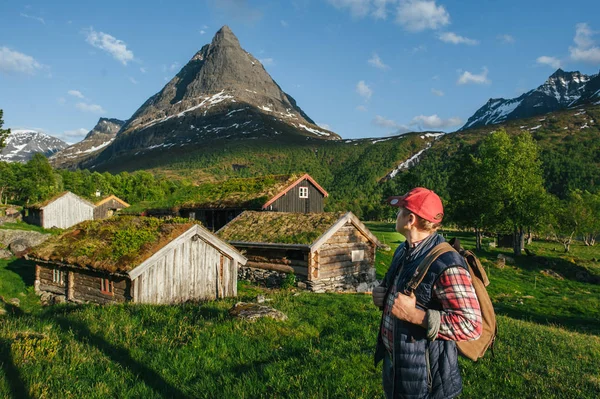 Hombre excursionista en Noruega cerca de casas tradicionales — Foto de Stock