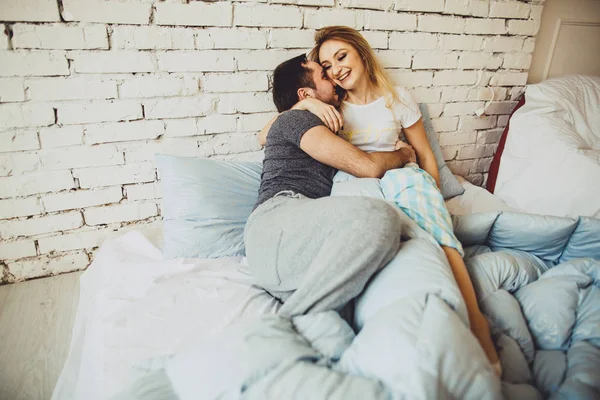 Jovem família relaxante na cama juntos . — Fotografia de Stock