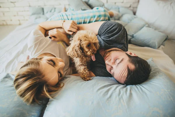 Jonge familie ontspannen op bed samen. — Stockfoto