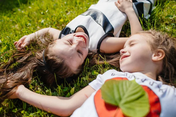 Zwei Mädchen liegen auf Gras — Stockfoto