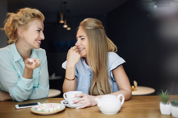 Women with hot coffee drink and  cookies