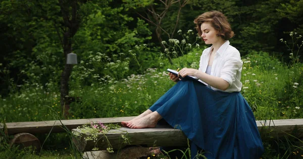 Jeune femme dans le parc avec livre — Photo