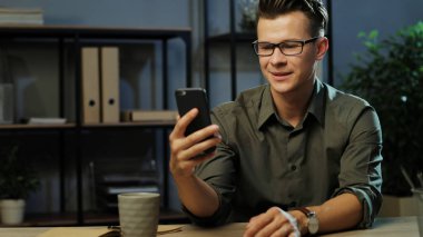 Genç adam akıllı telefon kullanıyor.