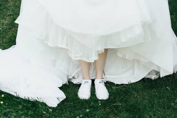 Bride dressed in long wedding dress and sneakers