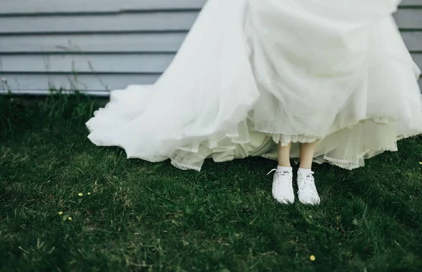 Bruden klädd i brudklänning och sneakers — Stockfoto