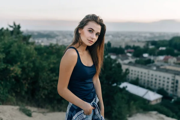 Menina em camisa preta posando na colina — Fotografia de Stock