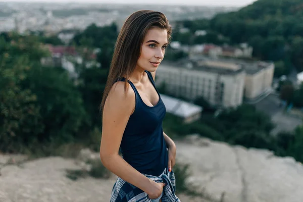 Mädchen im schwarzen Hemd posiert auf Hügel — Stockfoto