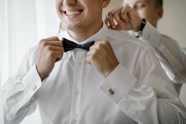 şık sağdıç mutlu yardımcı Damat Düğün töreni için sabah hazırlanıyor. Lüks Oda takım elbiseli bir adam. metin için yer. düğün günü.