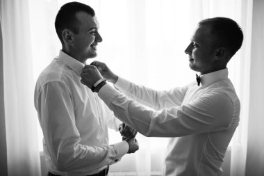 şık sağdıç mutlu yardımcı Damat Düğün töreni için sabah hazırlanıyor. Lüks Oda takım elbiseli bir adam. metin için yer. düğün günü.