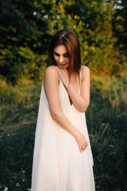 Doğa üzerinde poz uzun beyaz elbiseli genç kadın