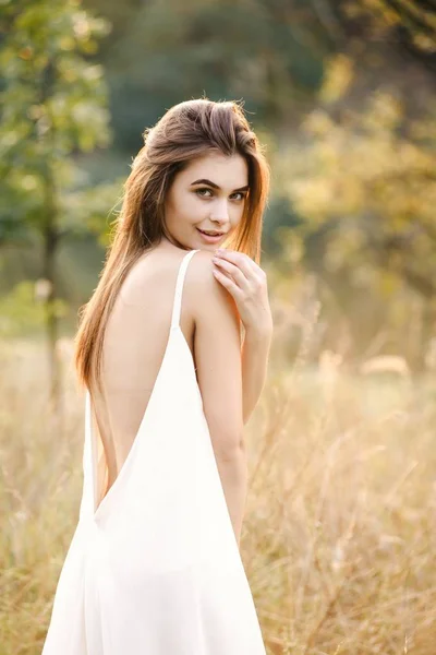 森でポーズ ロング ドレスで美しい若い女性 — ストック写真