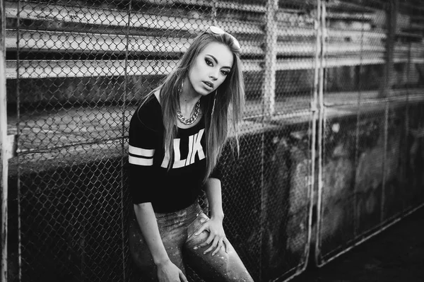 Young ,hipster woman  in  sporty  leggings and top posing on urban background