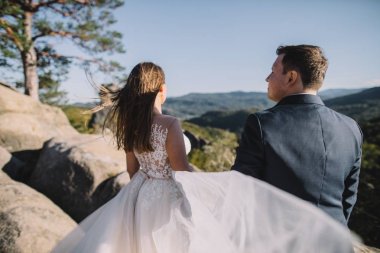 Muhteşem gelin ve şık damat yürüyüş güneşli manzara, Düğün çifti, muhteşem manzaralı lüks töreni dağlar