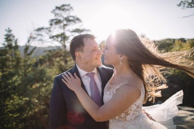 Muhteşem gelin ve şık damat yürüyüş güneşli manzara, Düğün çifti, muhteşem manzaralı lüks töreni dağlar