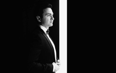 Yakışıklı damat gelin lüks otel odasında, sabah olmadan düğün töreni, kapalı şık takım elbise poz içinde romantik damat için bekleyen