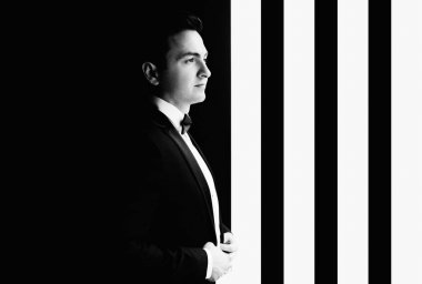 Gecenin düğün için hazırlanıyor süre pencerenin şık damat portre. lüks erkek takım papyon odada poz ile kendine güvenen bakışla. metin için yer.