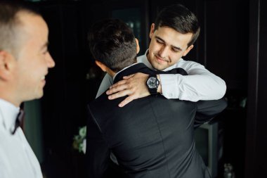 şık sağdıç mutlu yardımcı düğün töreni için sabah hazırlanıyor damat. Lüks Oda takım elbiseli bir adam. metin için yer. düğün günü.
