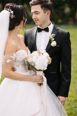 Güzel mutlu genç gelin güneşli Park yakışıklı damat öpüşme