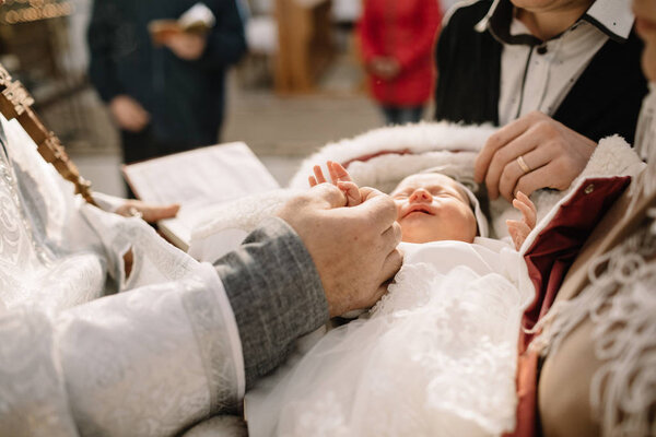 Perfect newborn baby sleeps during the baptism ceremony