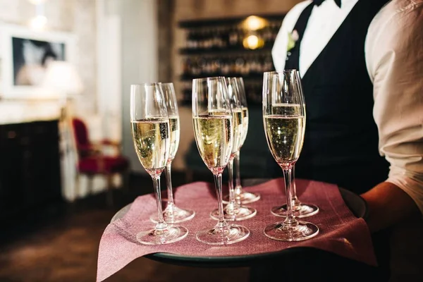 Garson bardak şampanya getiriyor — Stok fotoğraf