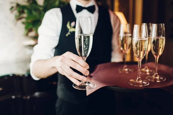 Garçom traz copos de champanhe — Fotografia de Stock