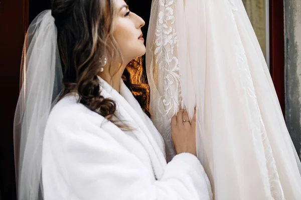 Красива Наречена Стоїть Перед Багатою Весільною Сукнею — стокове фото